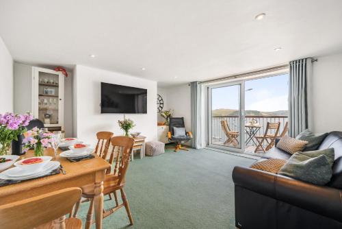 a living room with a couch and a table and chairs at N ° 42 The Salcombe in Salcombe
