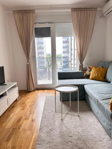 a living room with a blue couch and a table at Apartment Park in Novi Sad