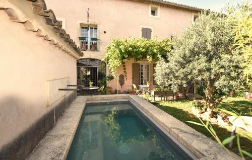 a swimming pool in a yard next to a house at Cozy Apartment In Morières-Lès-Avignon in Morières-lès-Avignon