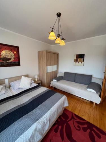 a hotel room with two beds and a couch at Willa Zuza in Kołobrzeg