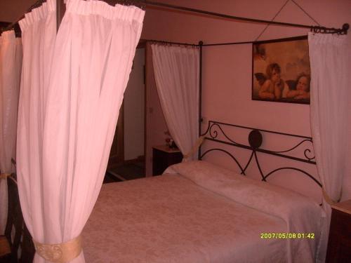 a bedroom with a bed with pink curtains at La Fattoressa in Florence