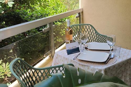 - une table avec une bouteille de vin et des verres sur un balcon dans l'établissement Studio boulouris cosy proche plage, à Saint-Raphaël