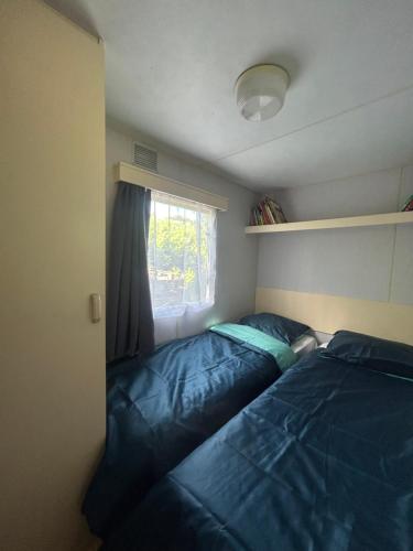 ein kleines Schlafzimmer mit einem Bett und einem Fenster in der Unterkunft Cabanon dans le jardin in Gaillac
