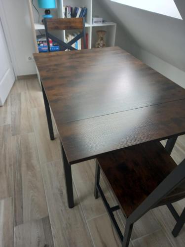 a wooden dining table with a bench on a floor at Côté plage in Groix