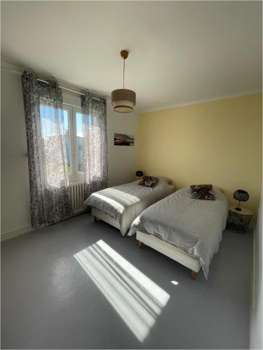 une chambre avec deux lits et une fenêtre dans l'établissement Maison location saisonniere, à Trouguennour