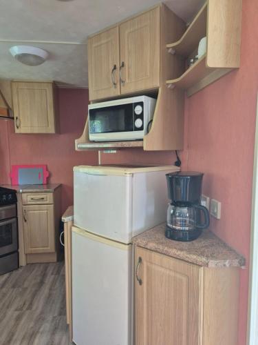 a small kitchen with a refrigerator and a microwave at Abi in Zalewo