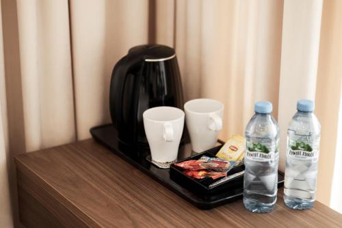 a tray with two bottles of water and a coffee maker at Aqua Bluemica ADULTS ONLY in Międzyzdroje