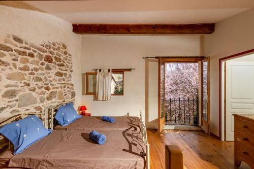 une chambre avec un lit et un mur en pierre dans l'établissement Villa en campagne avec cour intérieure, à Arques