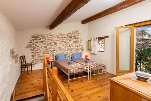 une salle à manger avec une table et un mur en pierre dans l'établissement Villa en campagne avec cour intérieure, à Arques