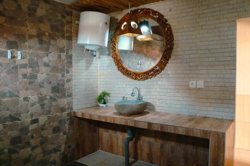 a bathroom with a sink and a mirror at De Olas Padang Padang Bali in Uluwatu