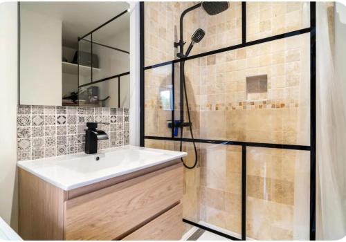 une salle de bain avec un lavabo et une douche dans l'établissement Maison de charme, à Créances