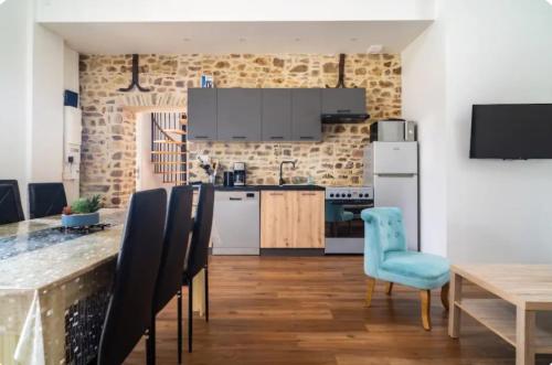 une cuisine et une salle à manger avec une table et des chaises dans l'établissement Maison de charme, à Créances