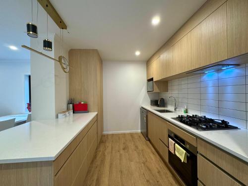 a kitchen with wooden cabinets and a stove top oven at NO PARTY ALLOWED, Entire Brand New 3 bedroom townhouse, free unlimited fibre wifi and free parking in Wellington
