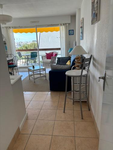 un salon avec un canapé, une table et des chaises dans l'établissement Appartement centre ville avec parking, à Quiberon