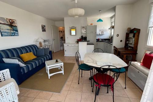 un salon avec un canapé bleu et une table dans l'établissement Appartement centre ville avec parking, à Quiberon