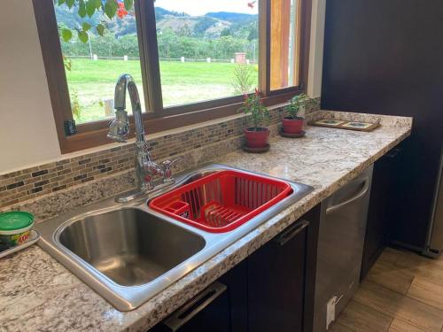 a kitchen sink with a red dish drainer in it at Hacienda Otavalo Country Home in Otavalo
