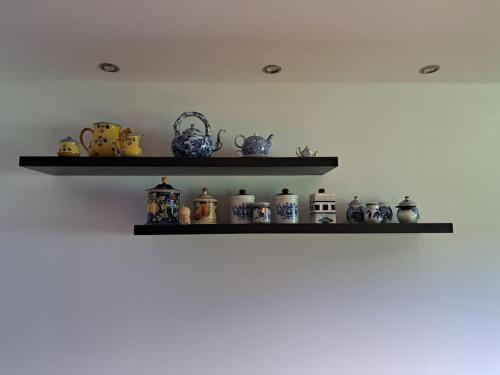 a shelf with a bunch of ceramics on it at Hacienda Otavalo Country Home in Otavalo