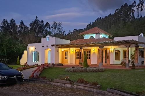 a house with a car parked in front of it at Hacienda Otavalo Country Home in Otavalo