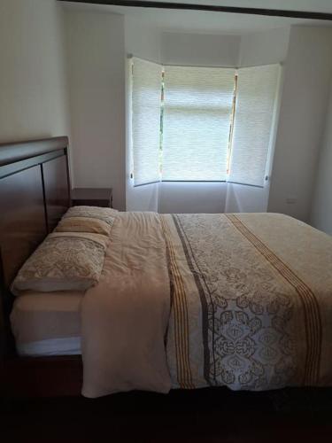 a bedroom with a bed and a window with a blanket at Hacienda Otavalo Country Home in Otavalo
