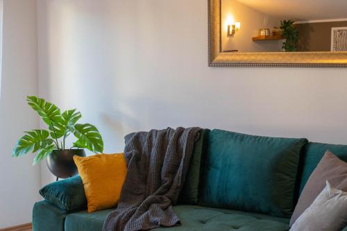 a green couch in a living room with a mirror at Apartments Anita Frane in Vodice