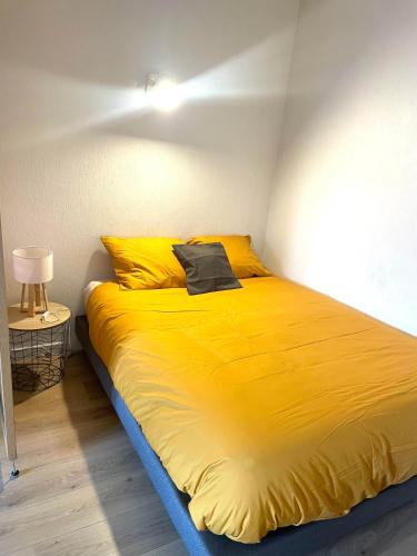 - un grand lit jaune dans une chambre avec une lampe dans l'établissement Le Calme-Proche Genève et Tram, à Ambilly