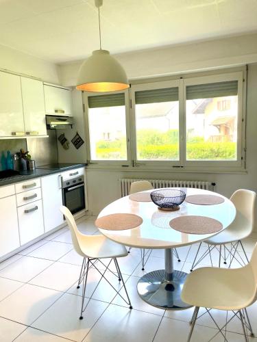 une cuisine avec une table et des chaises dans une cuisine dans l'établissement Le Calme-Proche Genève et Tram, à Ambilly