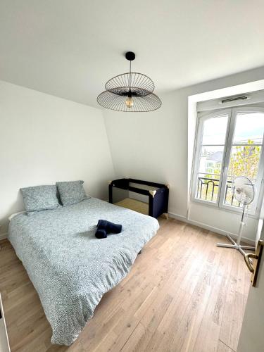 - une chambre avec un lit, un ventilateur et une fenêtre dans l'établissement Suite Médicis Near Disneyland, à Serris