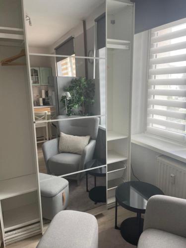 a living room with a chair and a mirror at Tiny Studio Pyskowice with parking in Pyskowice