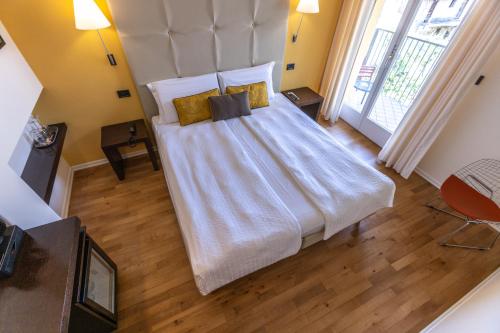 a bedroom with a large bed with white sheets and pillows at Hotel Meridiana in Malcesine