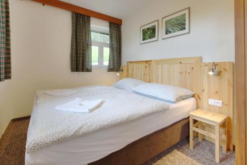 a bedroom with a large bed with a wooden headboard at Horský hotel Žižkova bouda in Pec pod Sněžkou