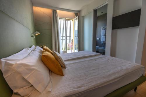 a bedroom with a large bed with white sheets and pillows at Hotel Meridiana in Malcesine