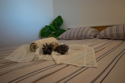 a bed with two towels and a plant on it at Apartments Anita Frane in Vodice