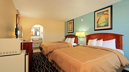 a hotel room with two beds and a television at Econo Lodge Austin South in Austin