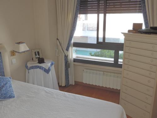 馬德里的住宿－雷迪羅公寓，一间卧室配有一张床、一个梳妆台和一扇窗户。