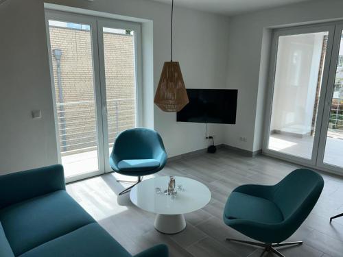 a living room with a couch and two chairs and a table at Timmendorfer Herz in Timmendorfer Strand