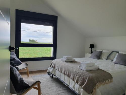 a bedroom with a large bed and a window at Apartamentos Islas Pantorgas in Tapia de Casariego