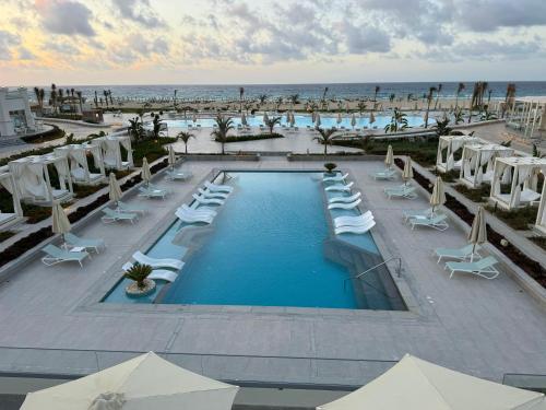 an overhead view of a pool with chairs and the beach at Cleopatra Sidi Heneish in Marsa Matruh