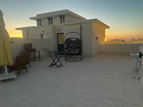 a patio with a chair on the roof of a house at Mohamed Afifi GAIA Ras El-Hekma - Penthouse 2BR- Families Only in Ras Elhekma