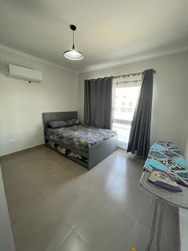 a bedroom with a bed and a window at Mohamed Afifi GAIA Ras El-Hekma - Penthouse 2BR- Families Only in Ras Elhekma