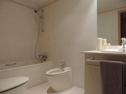a white bathroom with a toilet and a sink at Retiro Apartment in Madrid
