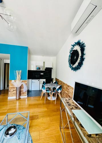 un salon avec une table et des chaises bleues dans l'établissement 2- Cosy one bedroom apt 2-4p, located Place Nationale, à Antibes