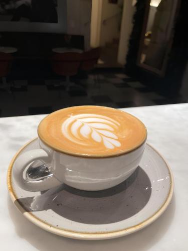 a cup of coffee on a plate on a table at Palazzo Boyl 1840 in Cagliari