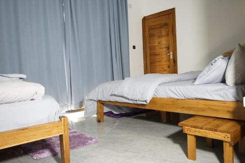 a room with two beds and a wooden bench at CosyBe Villas in Praia do Tofo