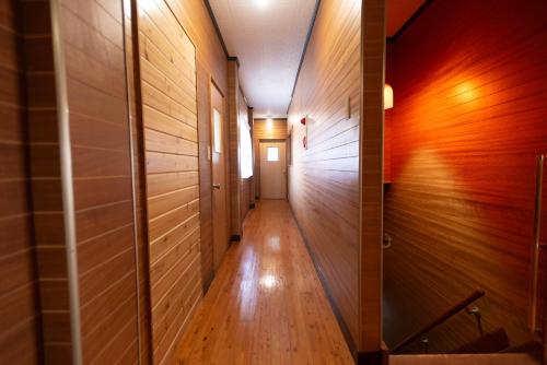 a hallway with wooden walls and a wooden floor at 富江宿 in Tomie