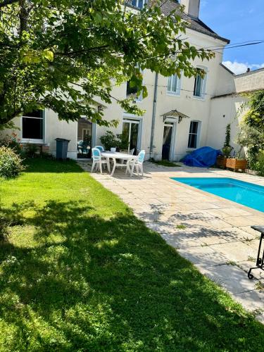 une arrière-cour avec une table et une piscine dans l'établissement maison cosy et chic, à Plancy