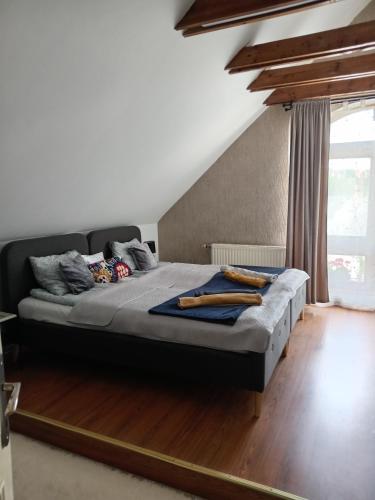 a bedroom with a large bed with wooden floors at Galeria Villa in Veszprém