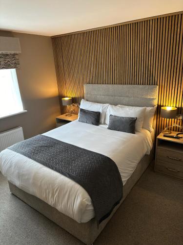 a bedroom with a large bed with two pillows at Castle Varagh Hotel & Bar in Westmeath
