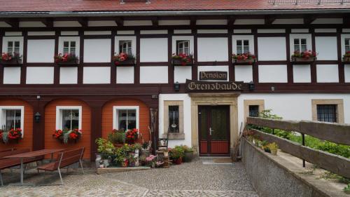 a building with flowerpots on the front of it at Pension Grenzbaude, Waltersdorf, Sachsen in Waltersdorf