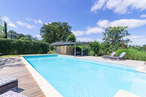 une piscine avec deux chaises et un gazebo dans l'établissement Domaine de la Garenne Ronel, à Ronel