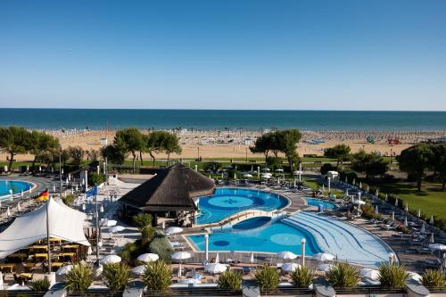 a view of a resort with a pool and the beach at Savoy Beach Hotel & Thermal Spa in Bibione